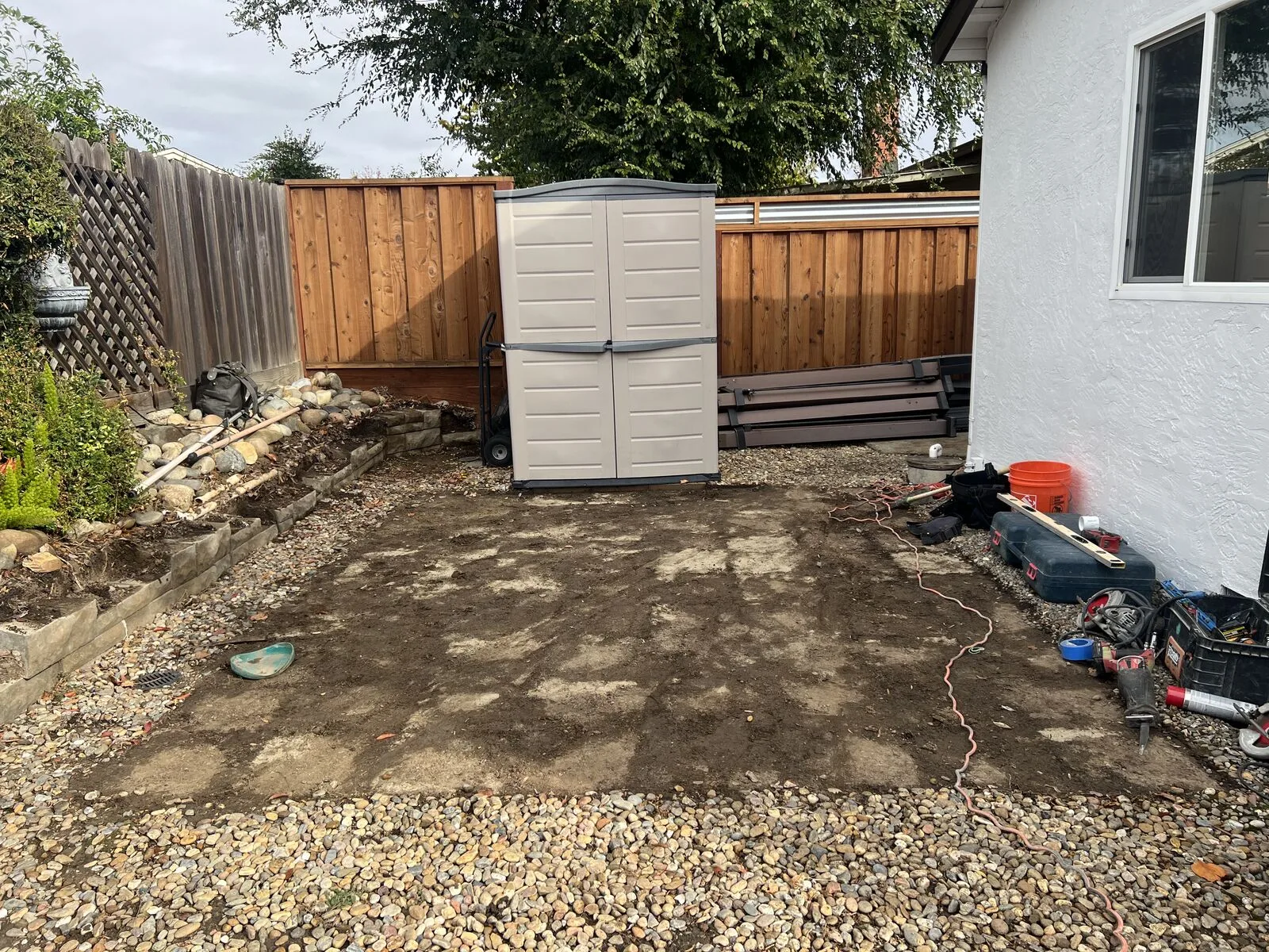 The Hernandez backyard after demolition, with the old surface removed beside the house.