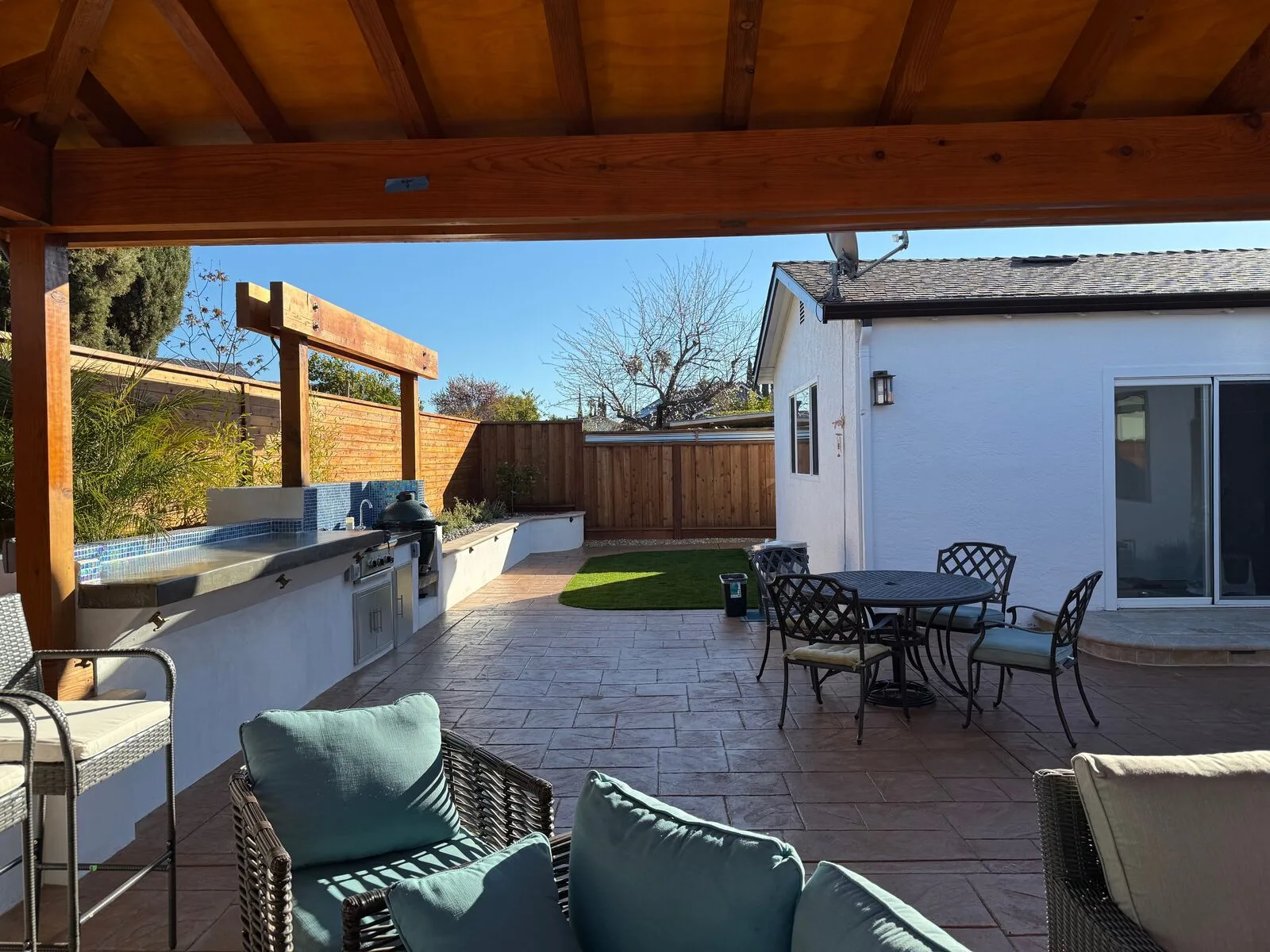A finished patio seating area looking toward the outdoor kitchen and garden.